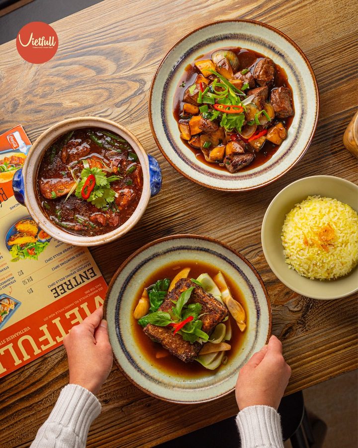 A table spread of VietFull dishes: claypot braise, crispy tofu, rice and a beef dish